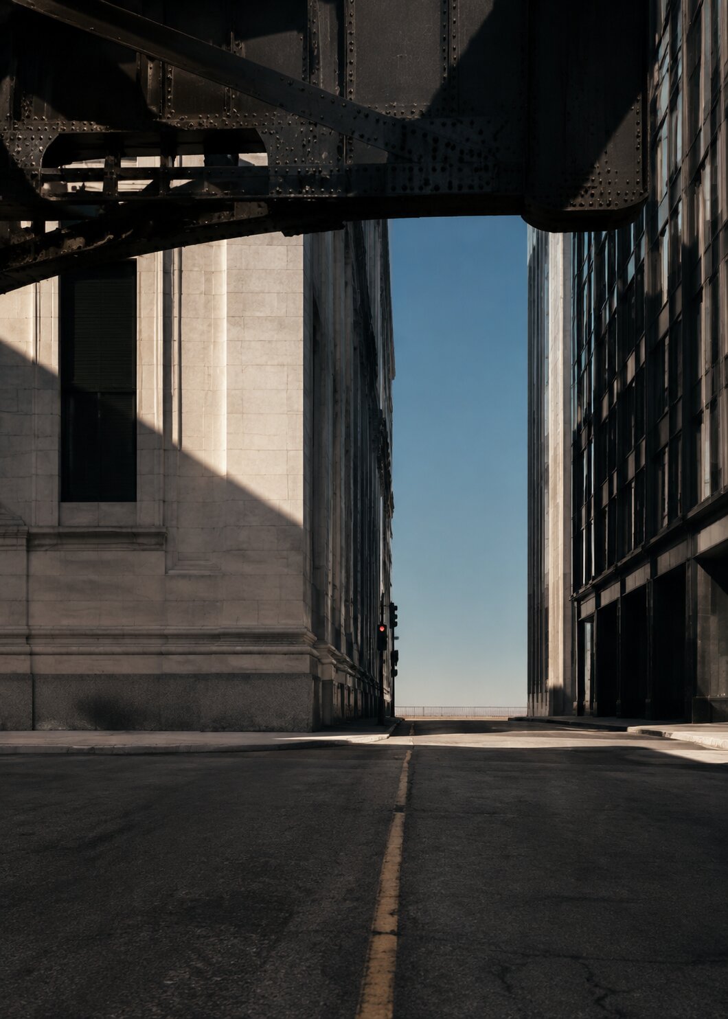 Narrow street between steel structures, a stone façade and a glass building in Chicago.