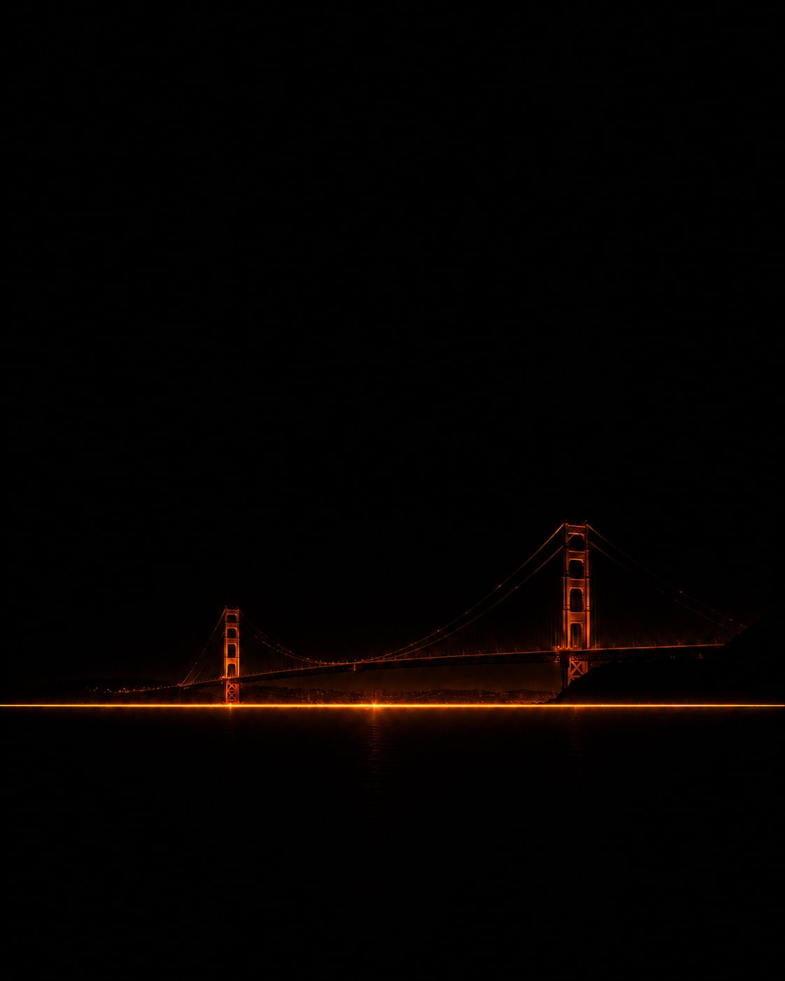 Le Golden Gate Bridge sombre traversant une ligne orange incandescente au-dessus d'une eau noire.