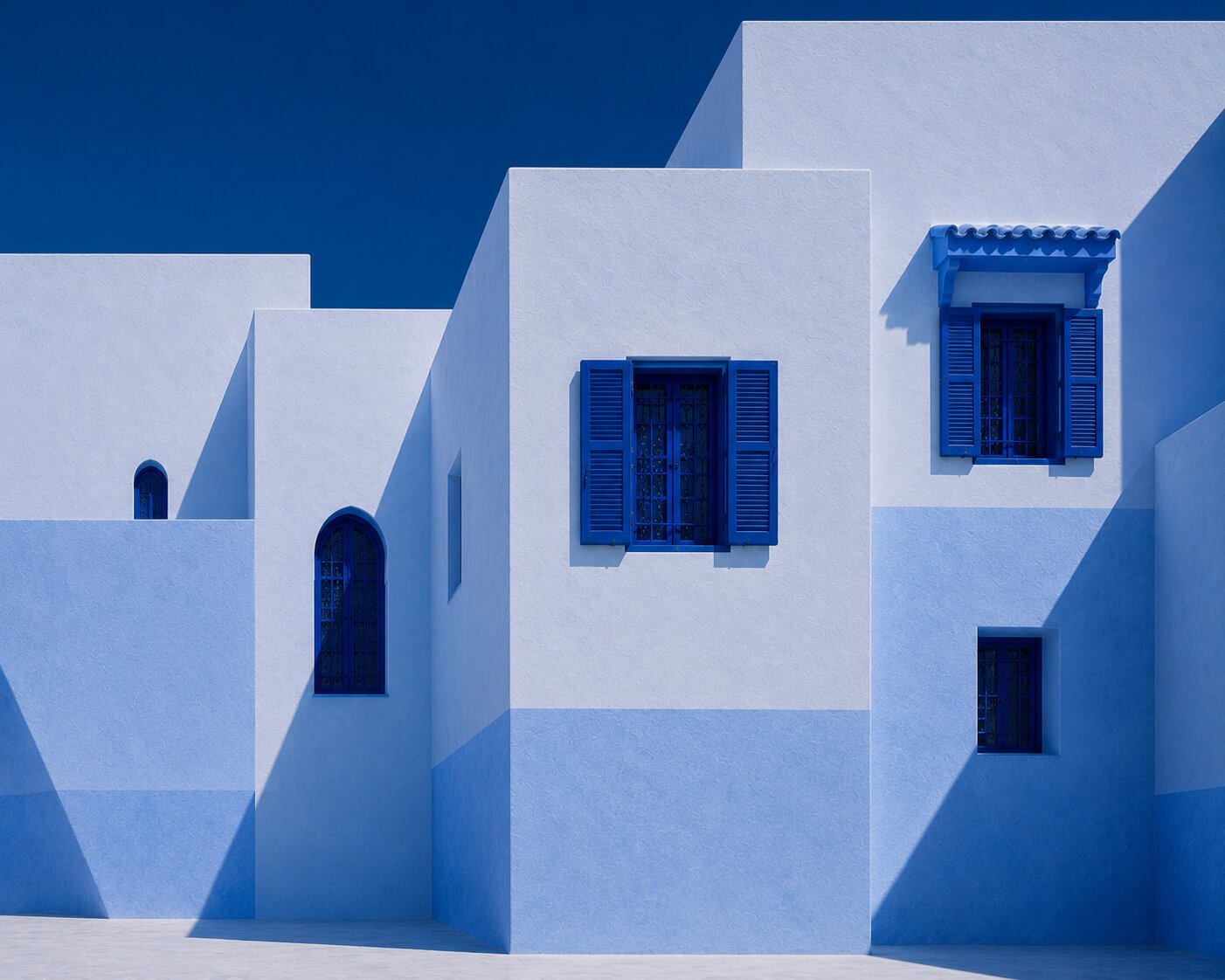 Geometric white Chefchaouen façades with windows, shutters and deep blue doors.